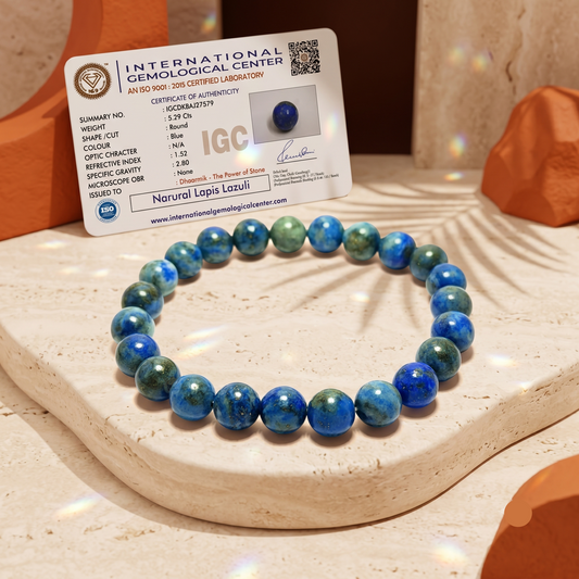 A beaded stretch bracelet made of round blue and green lapis lazuli stones, displayed on a stone pedestal with an authenticity certificate card from the International Gemological Center.